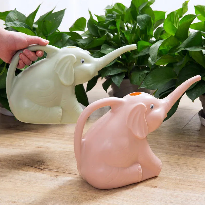 Blue elephant-shaped children's watering can with a long nozzle and baby bottle handle on a table.