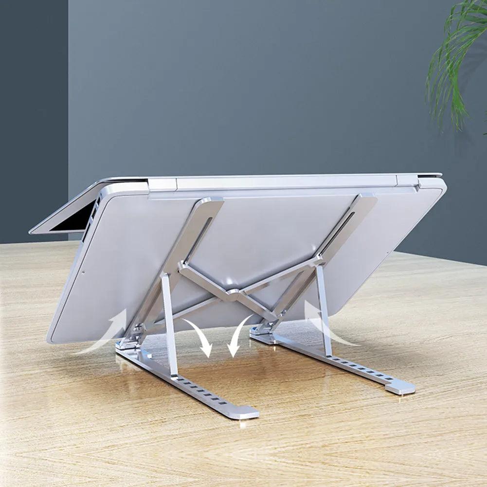 Silver foldable aluminium laptop stand holding a MacBook at an adjustable angle.