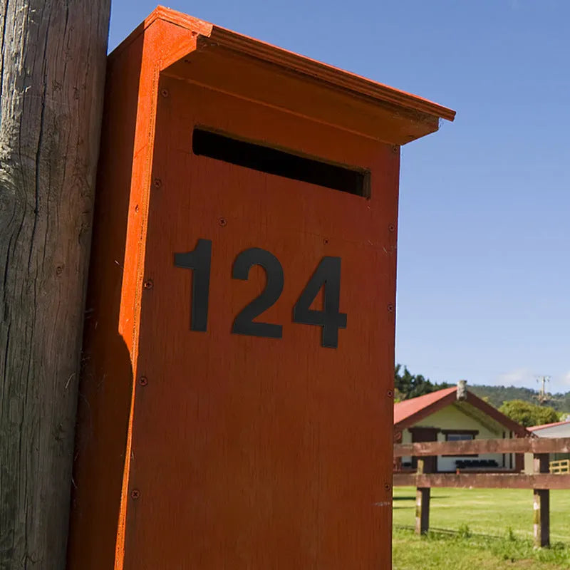 Black stainless steel adhesive house number sign showing digit 7, 7.5cm tall on adhesive backing.
