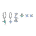 Gold and silver flower shaped stud earrings with zircon mosaic accents on white background