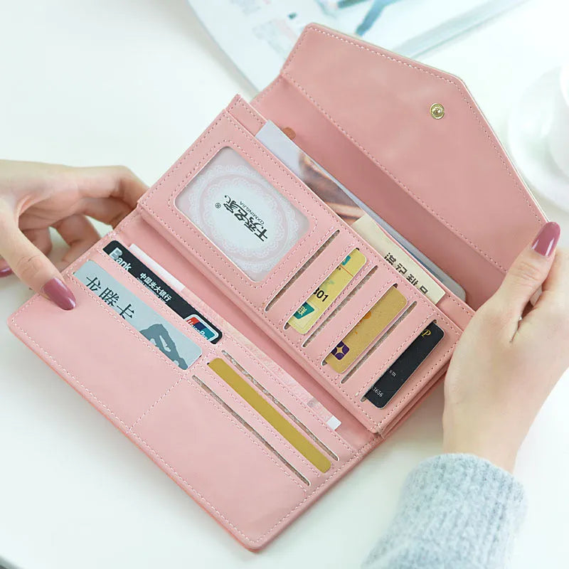 Women's black PU leather three-fold wallet with a buckle fastener, showing card slots and note compartment.