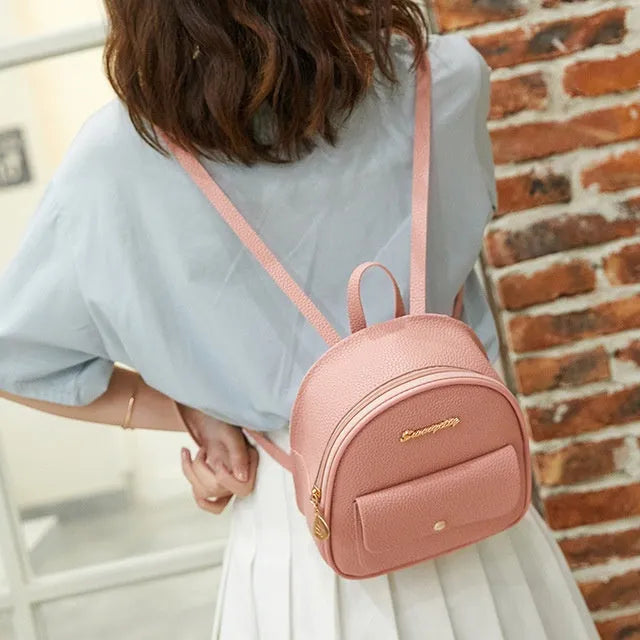Small black PU women's backpack with shoulder strap showing compact dimensions