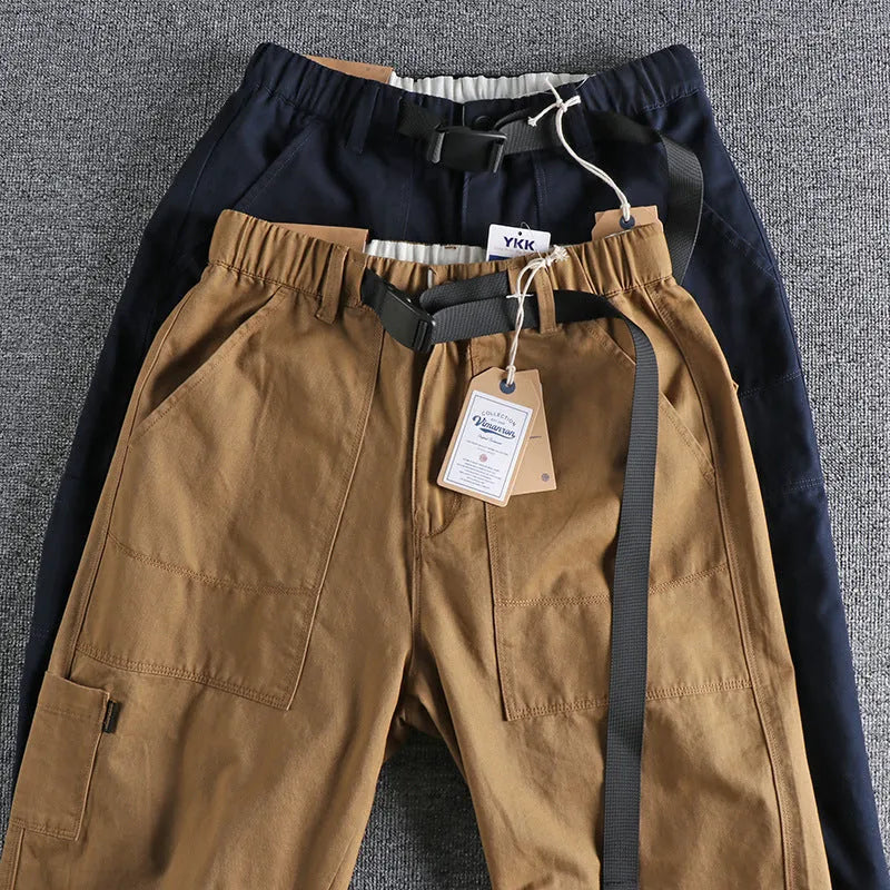 Men's khaki cotton work trousers with an N I buckle belt on a mid waist.