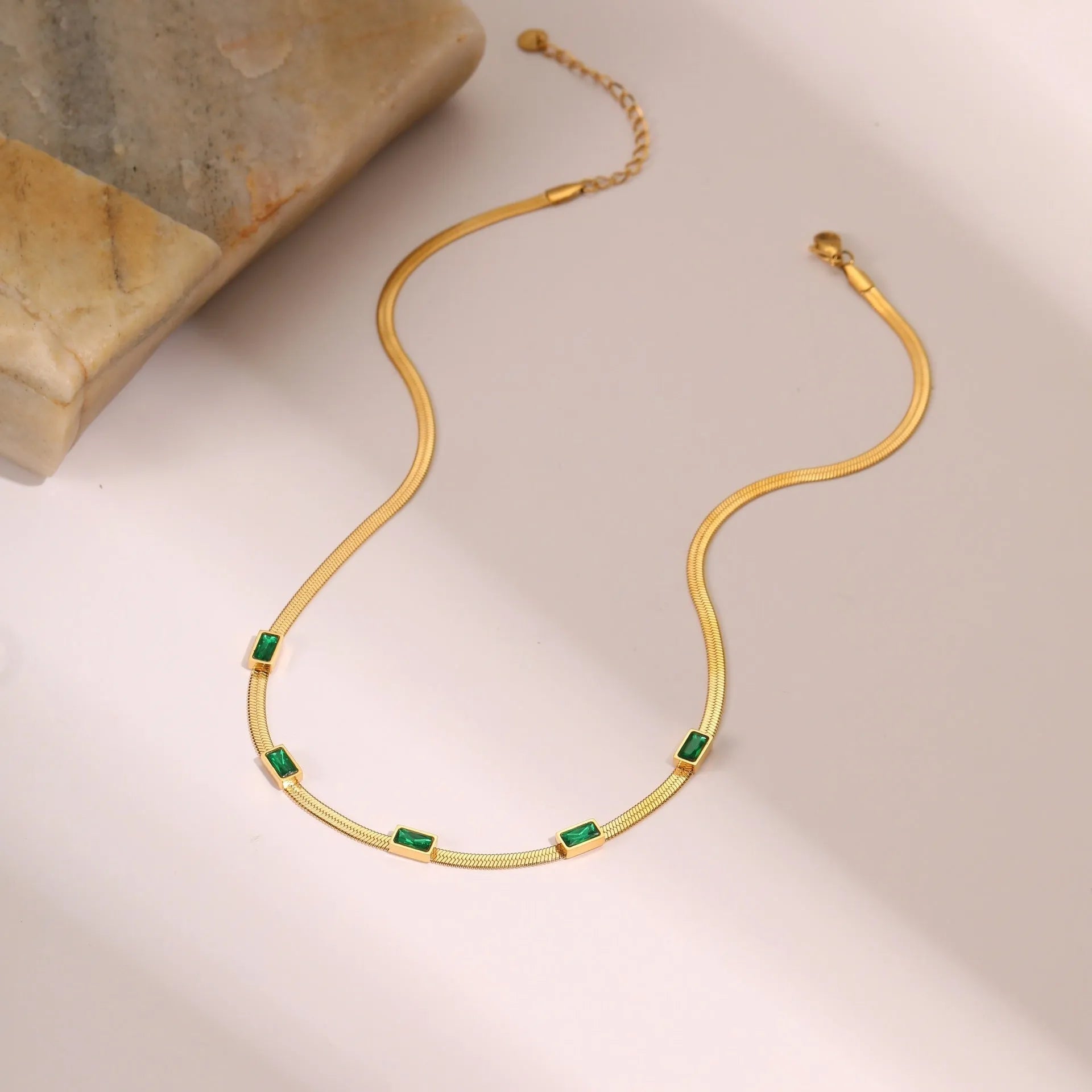 Geometric square zircon pendant on a stainless steel flat snake chain necklace.