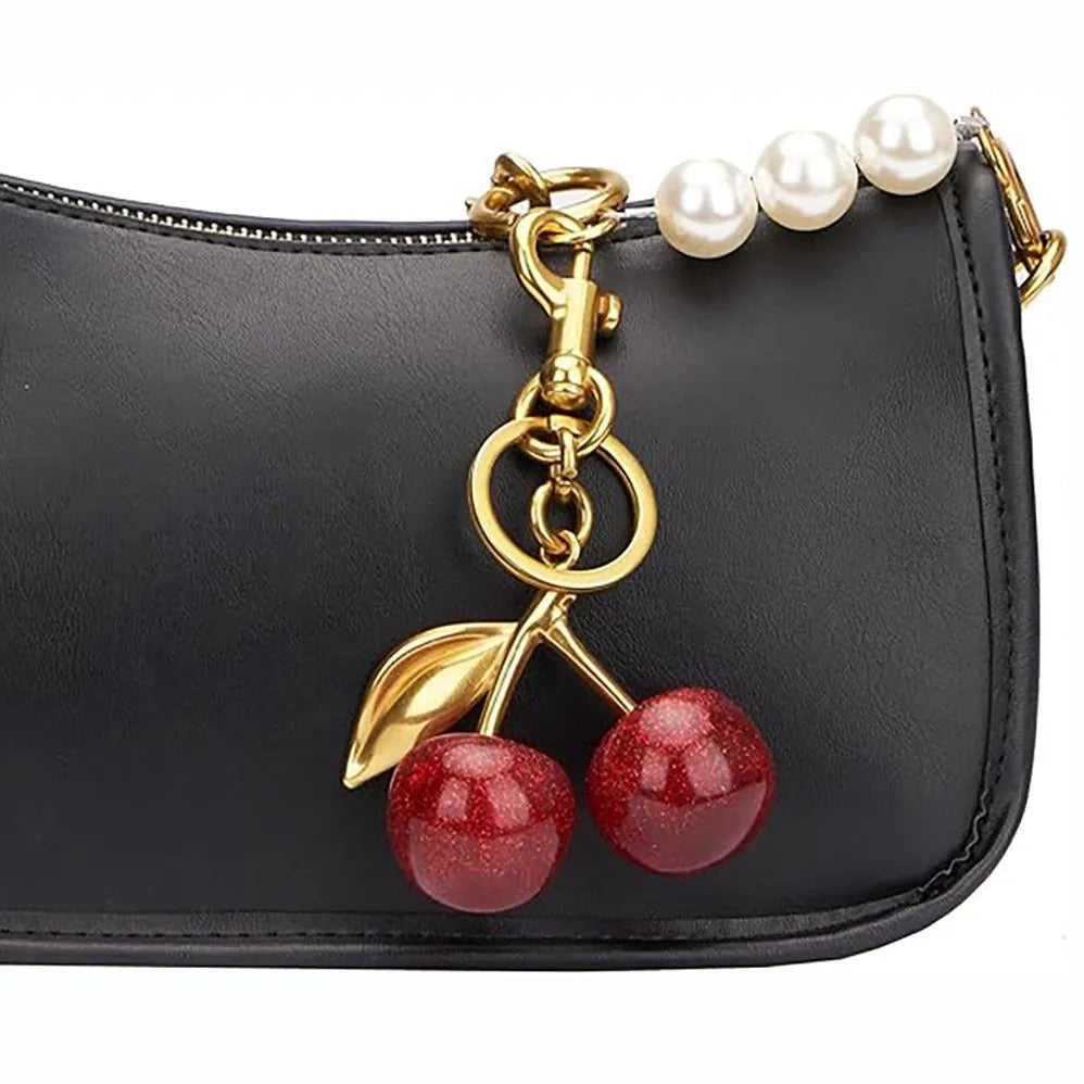 Close-up of a red zinc alloy cherry-shaped pendant key ring on a metal loop.
