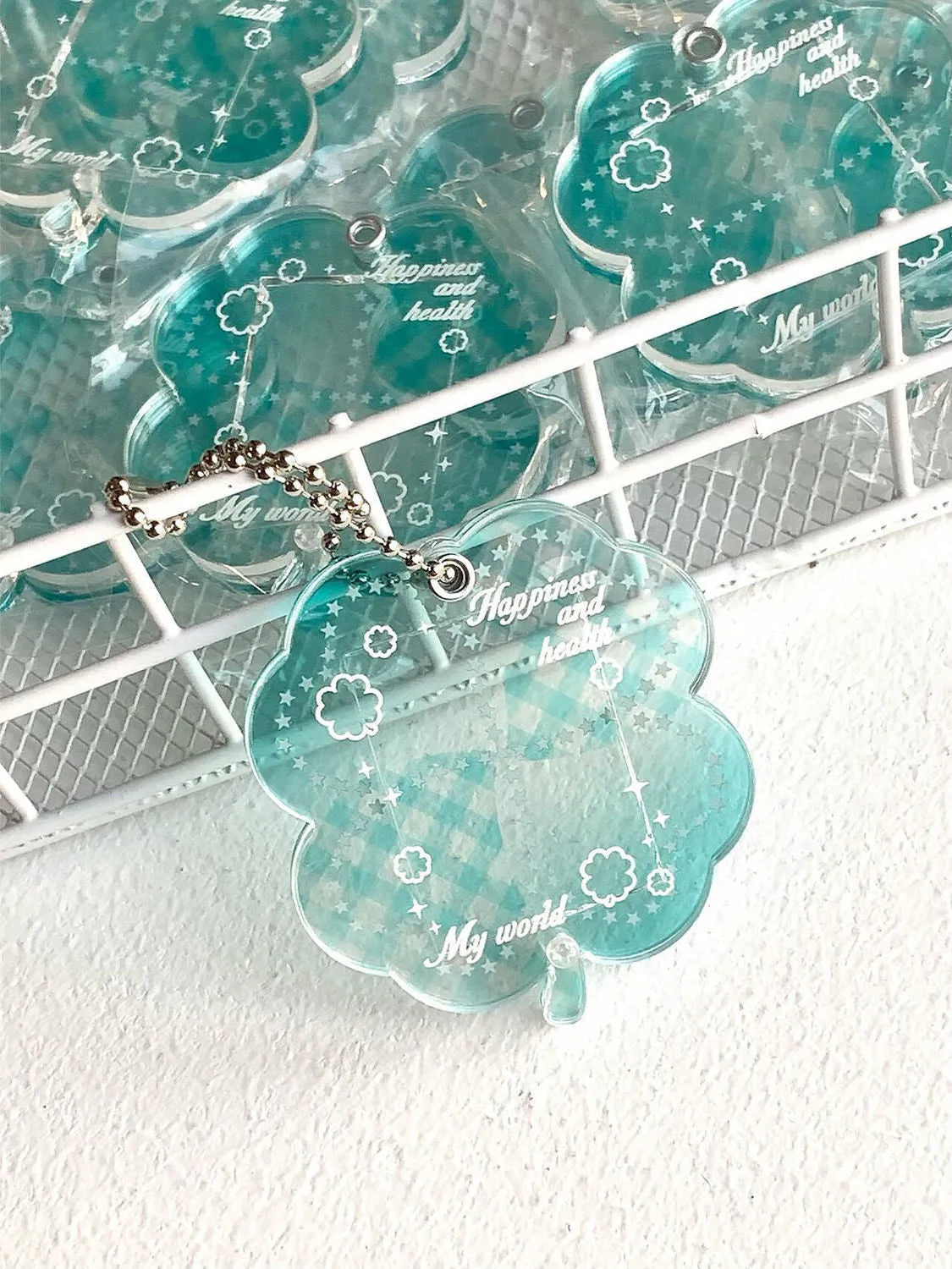 Blue four-leaf clover acrylic charm on a keychain ring.