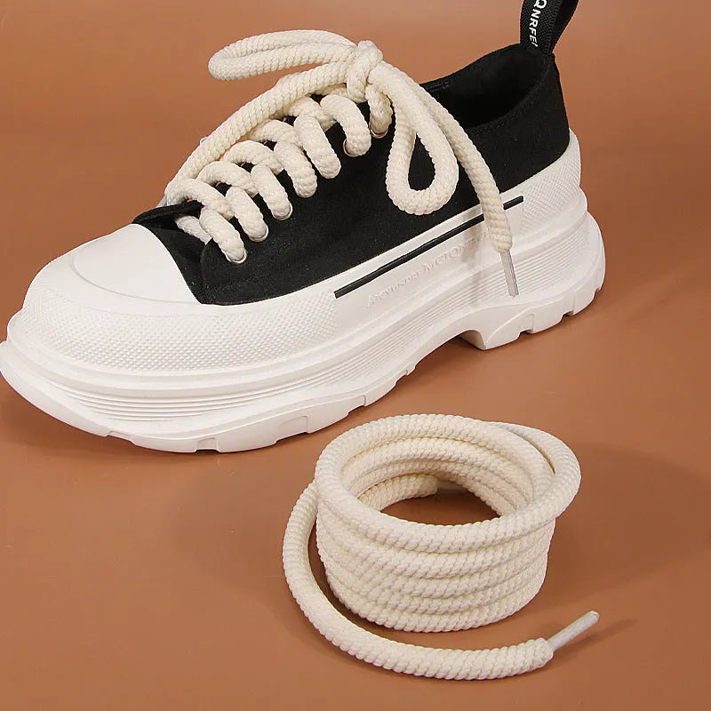 Round white woven shoelace on a grey background showing its 10mm diameter and textured weave.