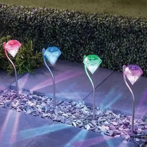 White solar-powered diamond-shaped garden spotlight with adjustable head on a stake for outdoor installation.