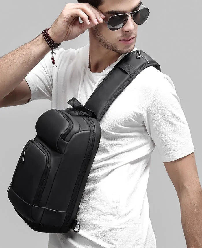 Black PVC outdoor shoulder bag with air cushion strap, soft handle, and laptop compartment