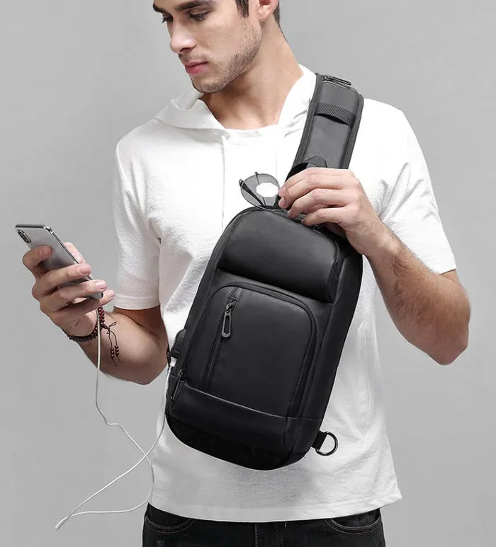 Black PVC outdoor shoulder bag with air cushion strap, soft handle, and laptop compartment