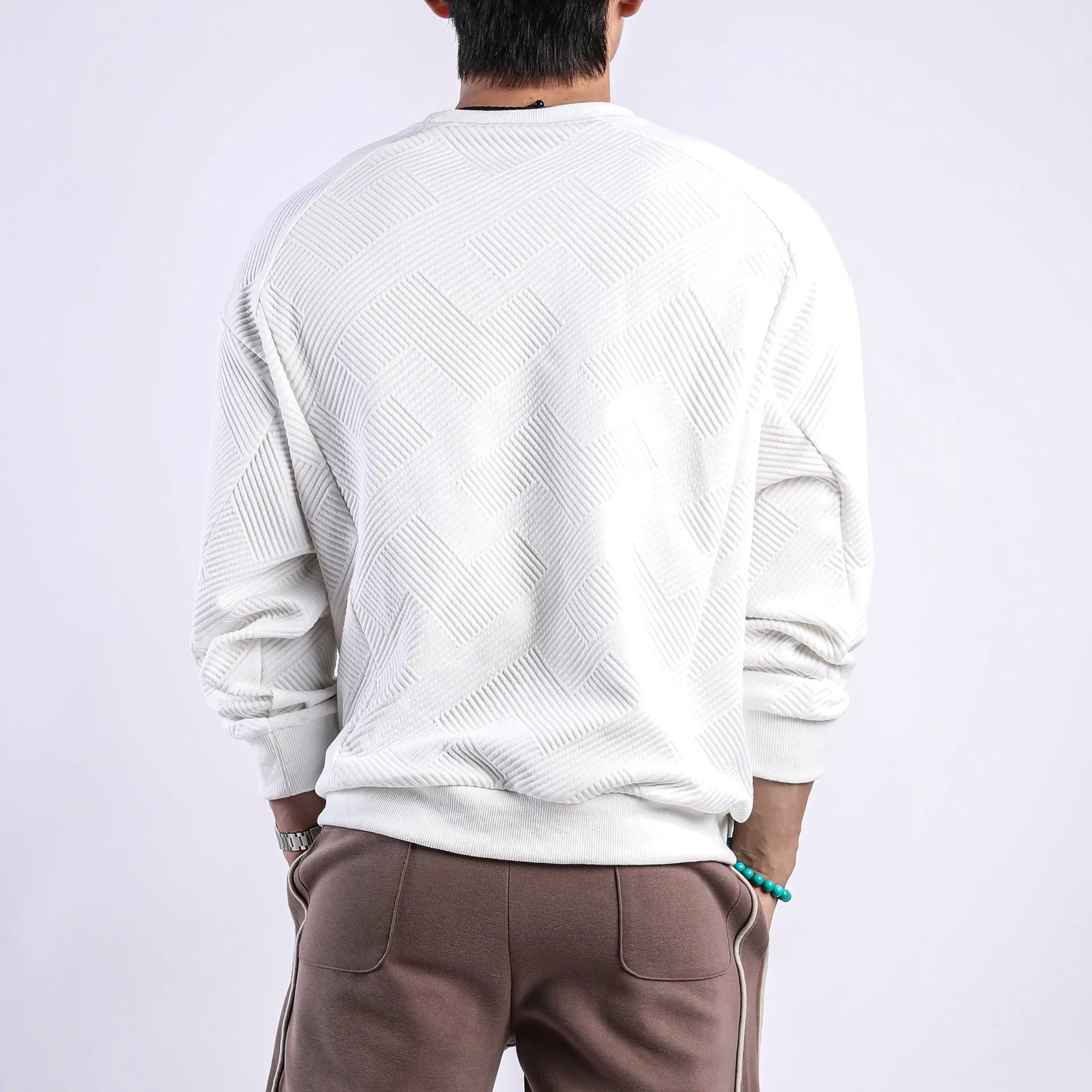 Men's solid colour twill jacquard long sleeve pullover sweater on a hanger.