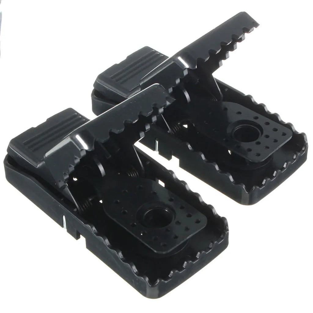 Six black plastic snapping mousetraps showing trigger mechanism and spring design