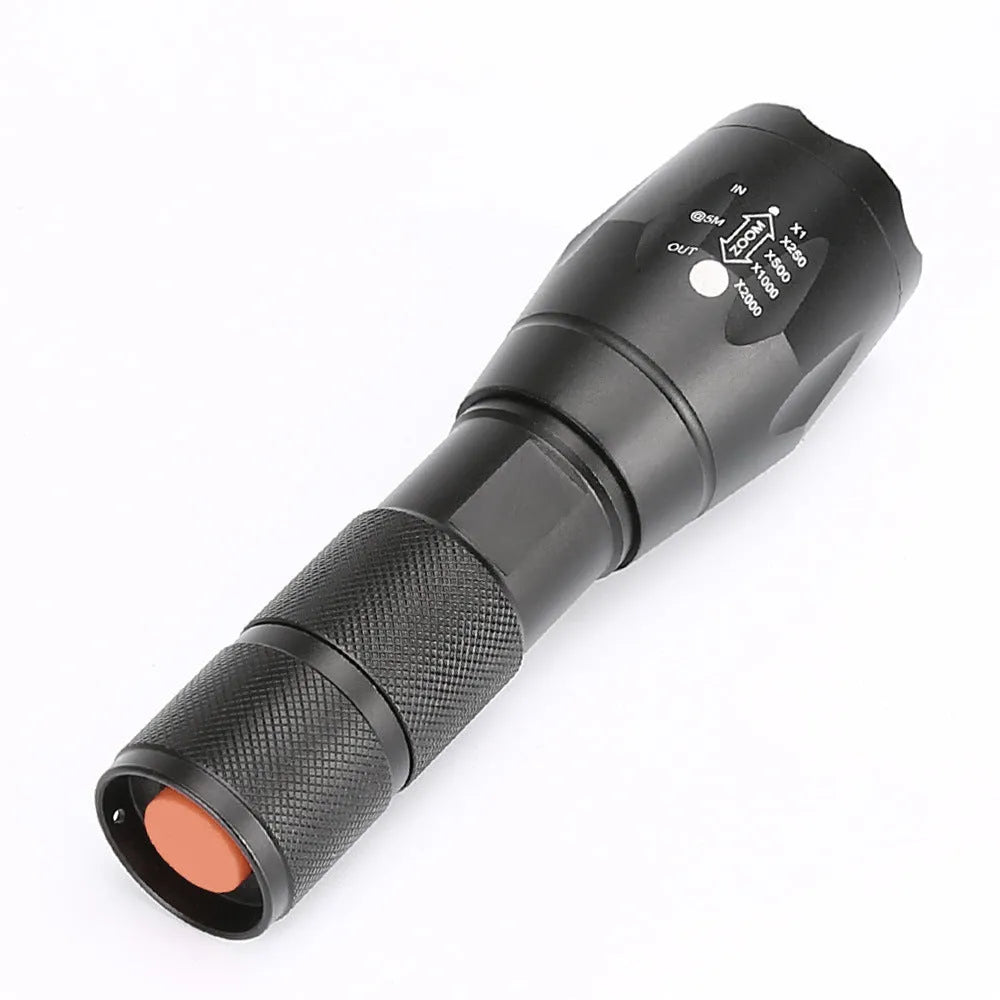 Black aluminium alloy LED zoom flashlight with adjustable focus head on a dark background.