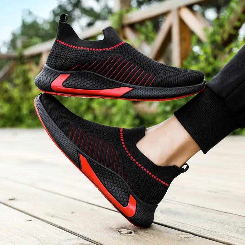 Men's black and white striped mesh slip-on sneakers with lace-up front on a plain background.