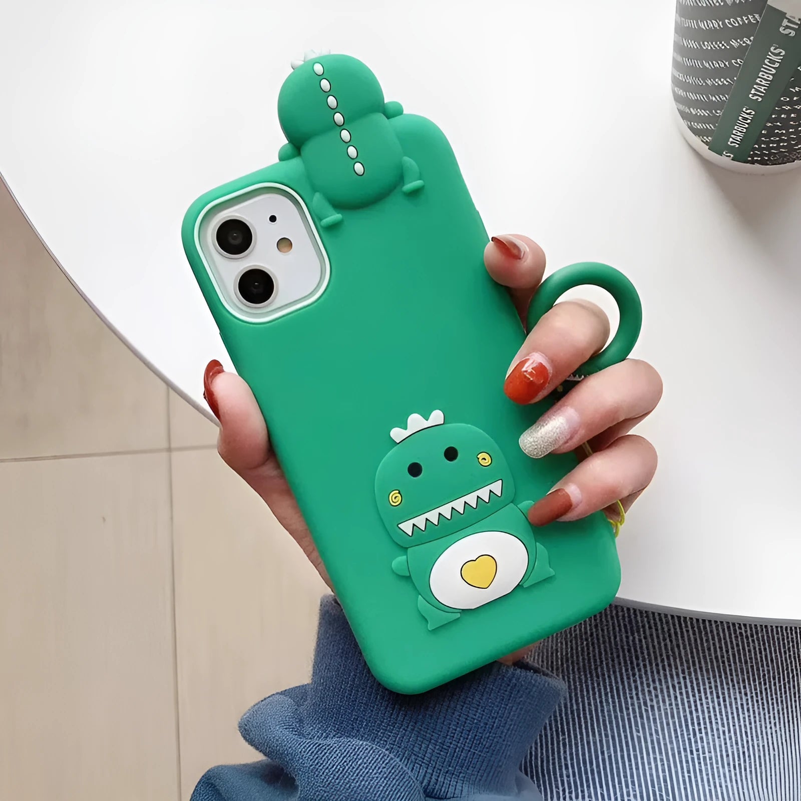 Green and yellow silicone phone cases with cartoon animal designs for Apple iPhones.