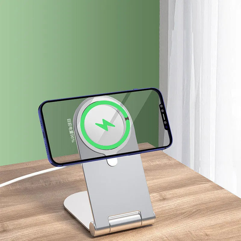 Silver portable magnetic bracket for iPhone 12, showing adjustable vertical stand on a desk.