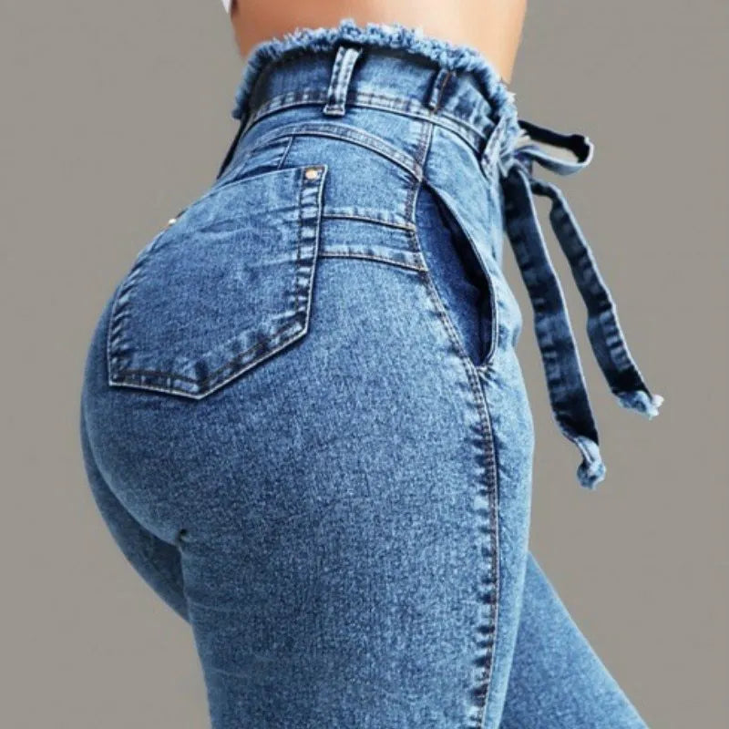 Men's dark blue jeans with frayed fringed hems laid flat on a surface.