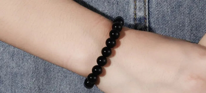 Women's black onyx bead bracelet with geometric design on a stretchy elastic cord.