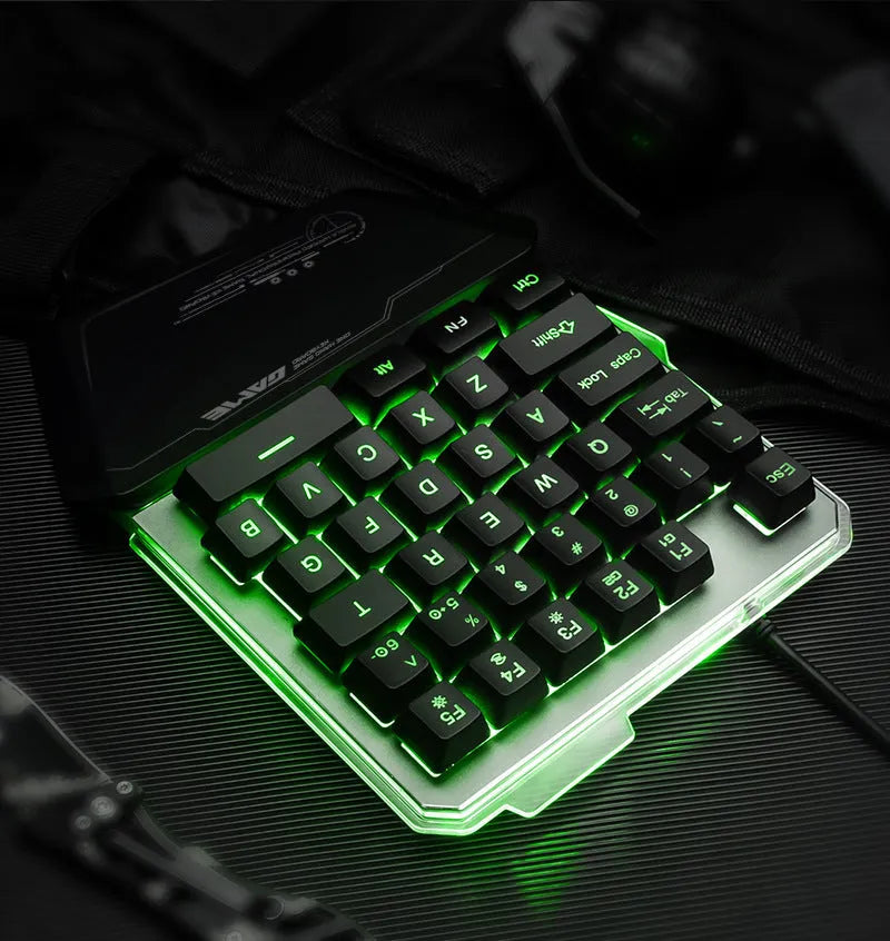 Black one-handed robotic gaming keyboard with RGB backlit keys on a desk.