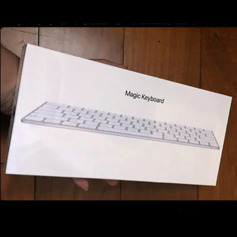 White Apple Bluetooth wireless keyboard with ultra-thin metal casing on a desk.