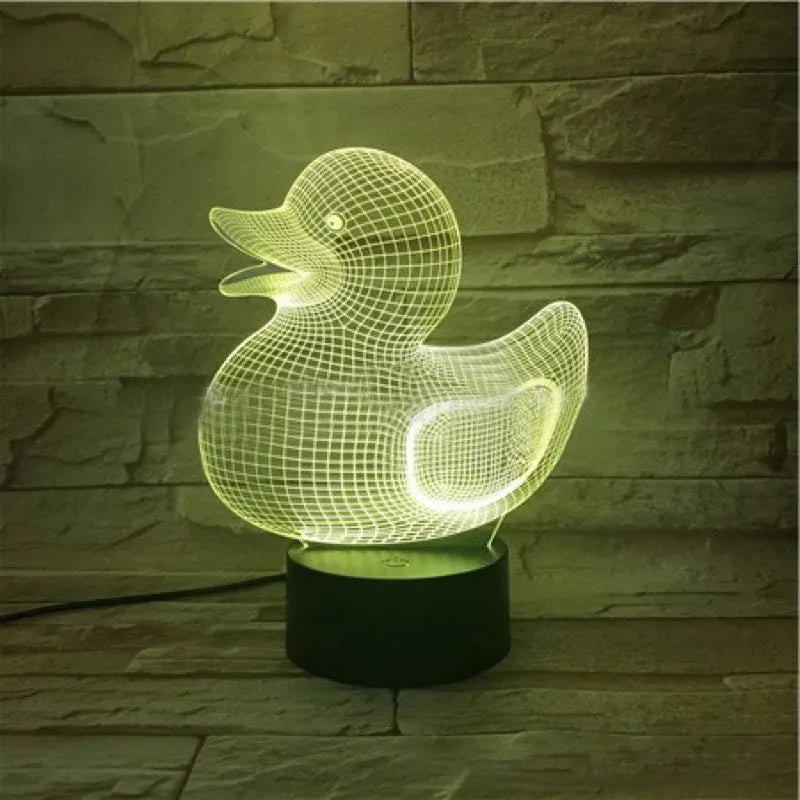 Yellow 3D duck-shaped LED night light on a table with remote control, showing multi-colour glow.