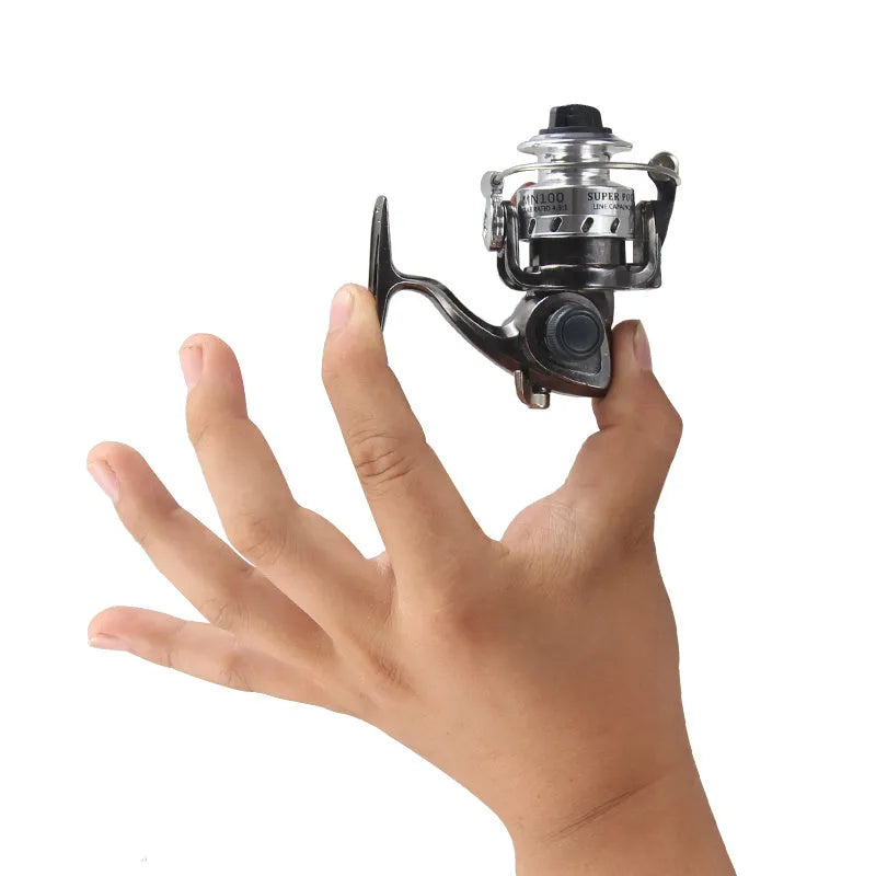 Mini 100 all metal black fishing reel with folding wooden rocker arm on white background