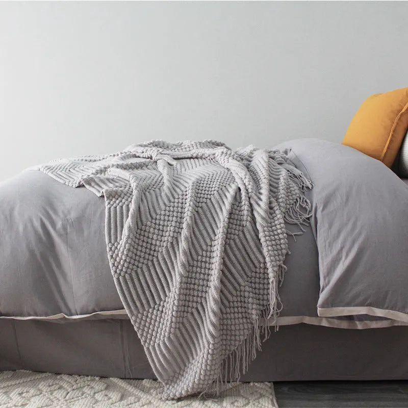 Small grey polyester blanket folded, dimensions 127 by 170 centimetres.