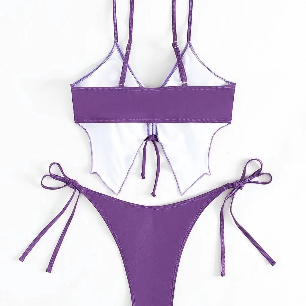 Purple women's bikini suit with bow detail and split design on a mannequin.