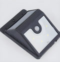 White rectangular solar-powered outdoor security light with four LED bulbs and an integrated solar panel on top.