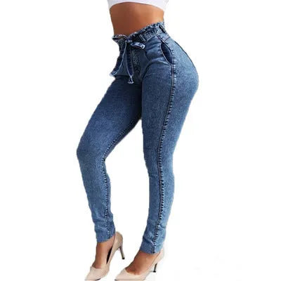 Men's dark blue jeans with frayed fringed hems laid flat on a surface.