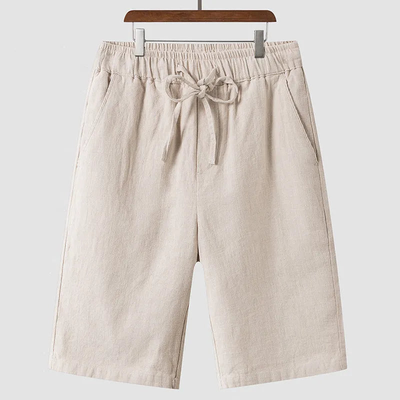 Man wearing beige linen casual shorts with a loose, cropped fit and elasticated mid waist.