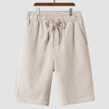 Man wearing beige linen casual shorts with a loose, cropped fit and elasticated mid waist.