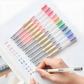 Set of twelve black Muji gel pens with 0.5mm fine tips, shown with caps off.