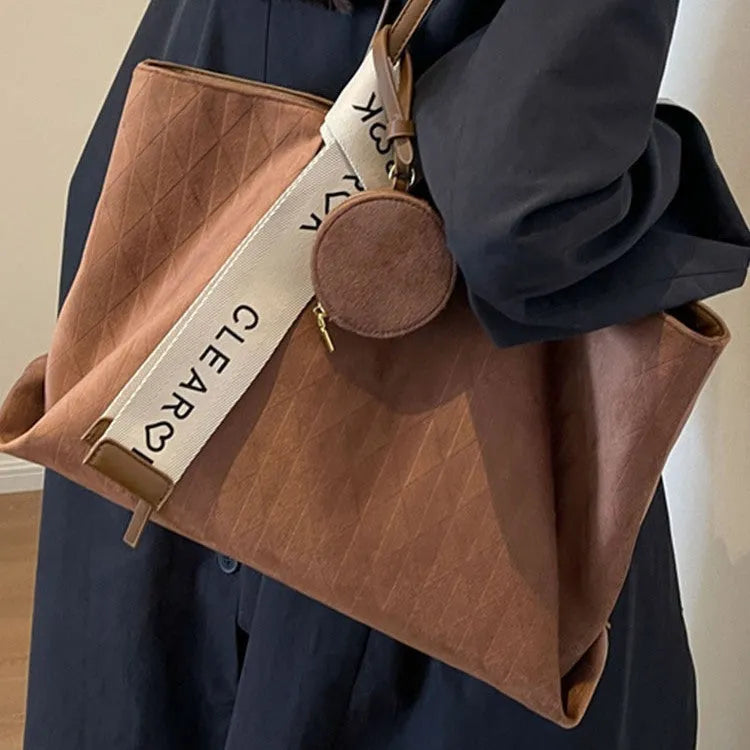 Soft large casual shoulder tote bag in a horizontal square shape with a sandwich pocket and sewing thread detail.