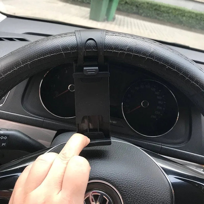 Black universal steering wheel phone holder clip mounted on a car steering wheel.