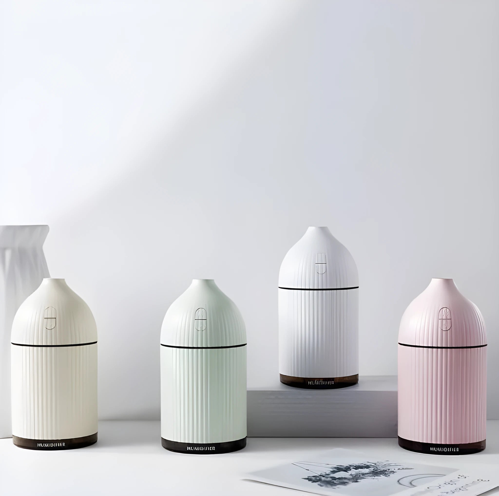 White cylindrical ultrasonic aromatherapy diffuser with LED light and 300ml water capacity.