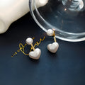 Close-up of women's simple heart-shaped stud earrings with a pearl-like finish and Korean style design.