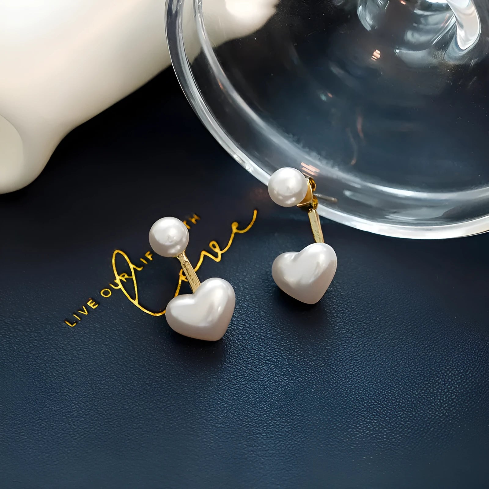 Close-up of women's simple heart-shaped stud earrings with a pearl-like finish and Korean style design.