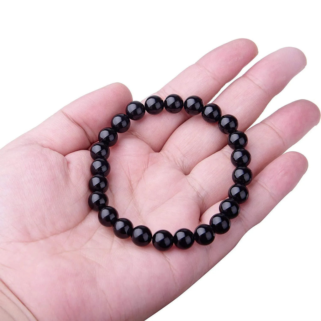 Women's black onyx bead bracelet with geometric design on a stretchy elastic cord.
