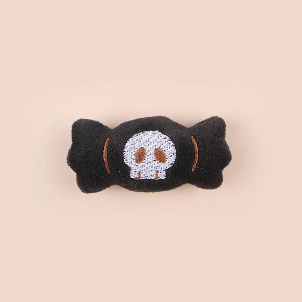 Small plush cat teaser wand toy showing candy, skull and eye patterns on soft fabric