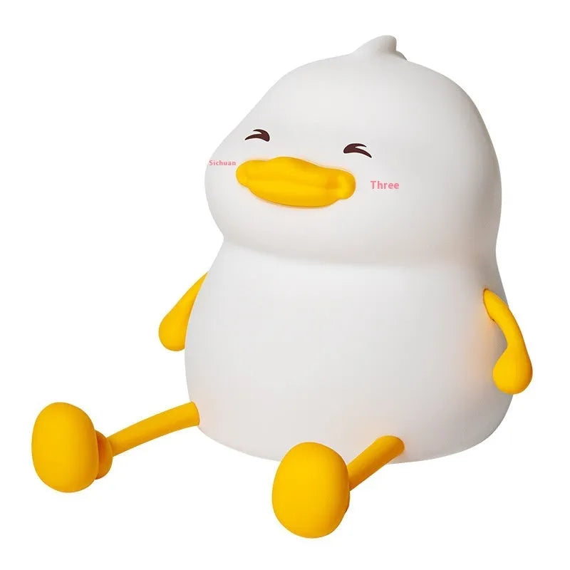 Chubby white USB rechargeable LED night light with built-in silicone phone holder on its base.