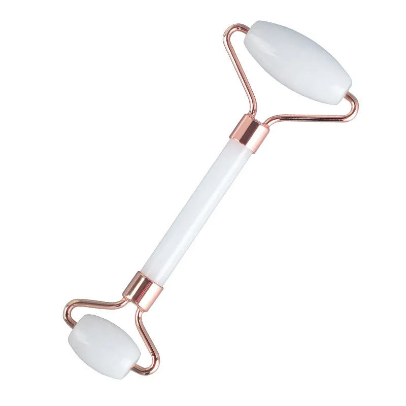 White jade facial roller and gua sha scraping tool set on a storage board.