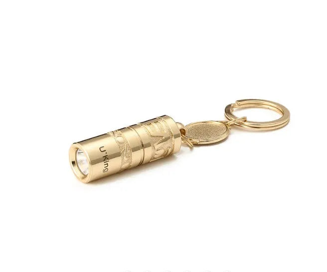 Gold-coloured waterproof mini LED keychain flashlight with zinc alloy housing on a key ring.