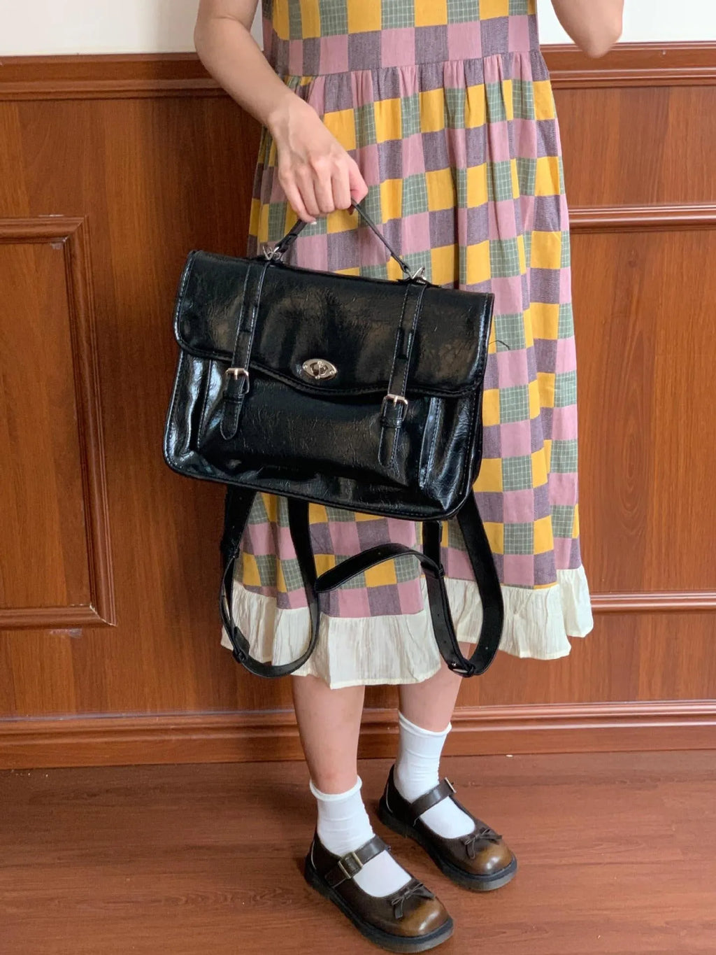 Black college style messenger bag for women made from oil wax leather-look PU material.