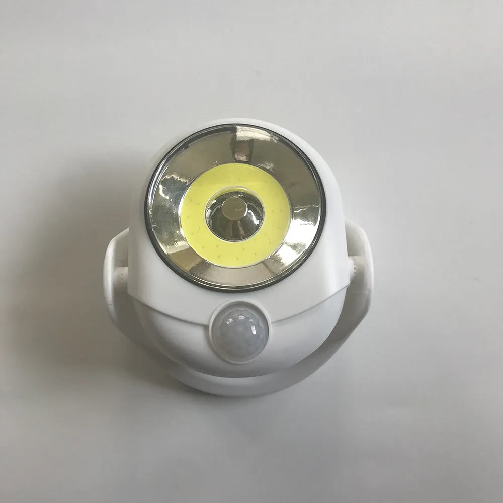 White Atomic Angel induction light with dimensions 13.3cm by 9.8cm by 15.8cm