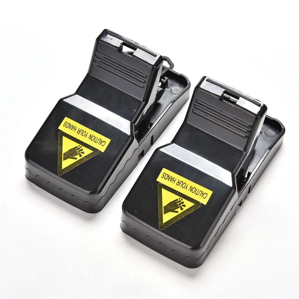 Six black plastic snapping mousetraps showing trigger mechanism and spring design