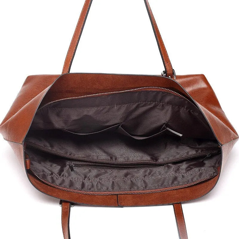 Brown leather crossbody handbag showing two main compartments and a front phone pouch