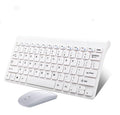 Black and white wireless keyboard and mouse set on a wooden desk