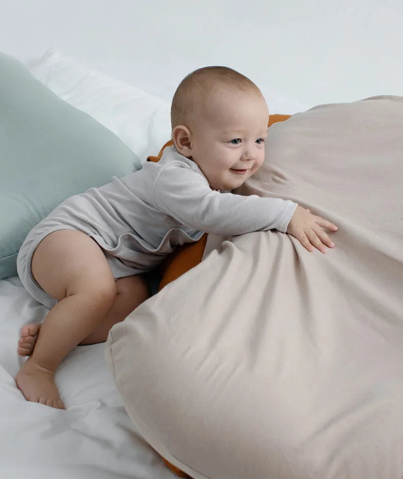 Beige portable baby nest crib cushion measuring 75cm by 45cm on a neutral background