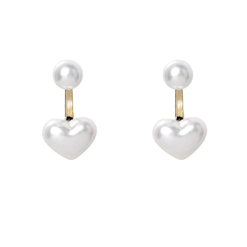 Close-up of women's simple heart-shaped stud earrings with a pearl-like finish and Korean style design.